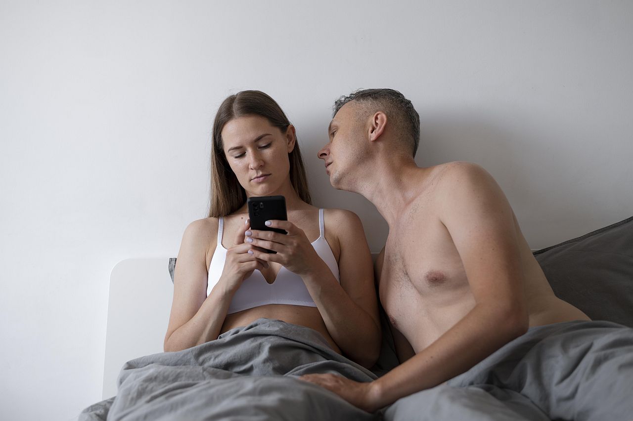 Zamilovaný pár v posteli uvažuje o polygamnom vzťahu